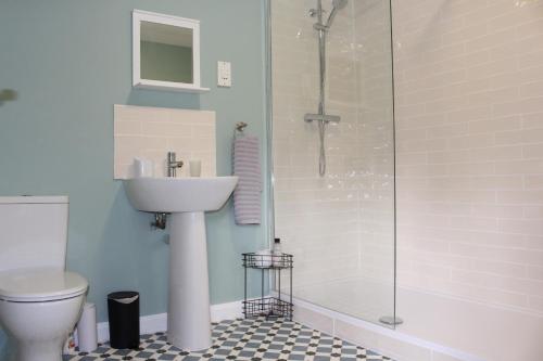 a bathroom with a toilet and a sink and a shower at Seashell Cottage in Llanddulas