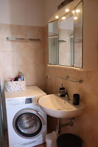 uma casa de banho com uma máquina de lavar roupa e um lavatório em Star on the lake em Garda