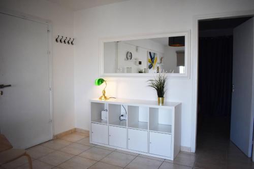 a white cabinet in a room with a mirror at Sunny Rooftop in Ayia Napa 91Sqm Terrace Delight! in Ayia Napa