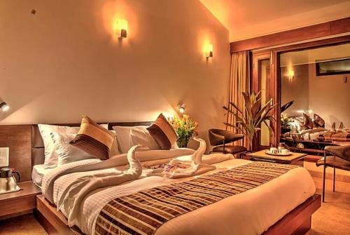 una camera con due cigni su un letto di Hotel Palm Royal Palace Bhimtal a Bhimtal