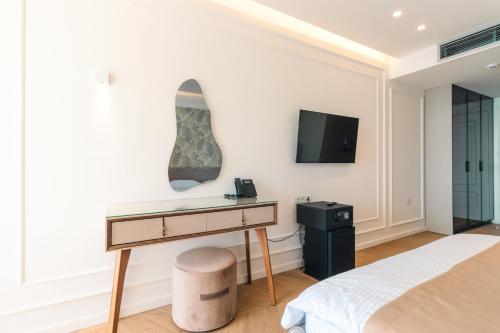 a bedroom with a desk and a tv on the wall at Miramar in Ulcinj