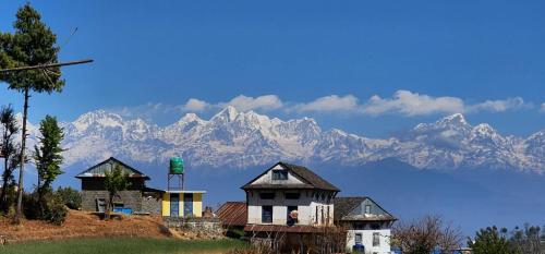 PanaotiにあるDhunkharka Homestayの山を背景にした丘の上の住宅