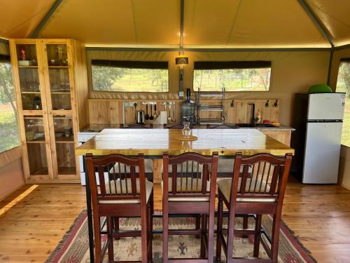 a kitchen with a table and chairs in a tent at Nyumba ya Farasi in Naivasha