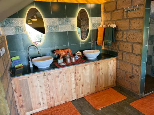 a bathroom with two sinks and two mirrors at Nyumba ya Farasi in Naivasha