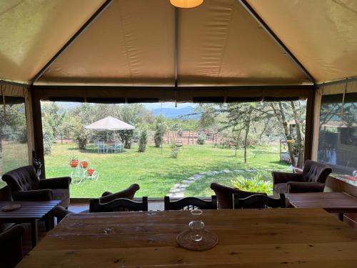 a tent with a table and chairs and a large window at Nyumba ya Farasi in Naivasha