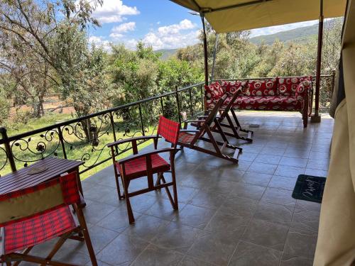 a porch with chairs and a couch on a balcony at Nyumba ya Farasi in Naivasha