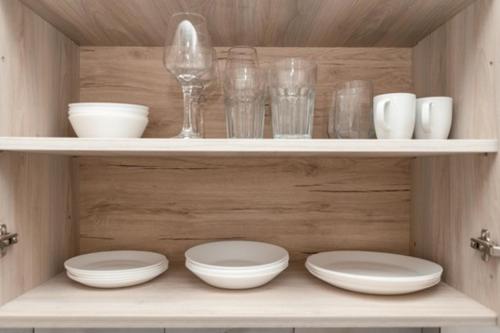 a shelf with plates and bowls and glasses on it at Hidden Paradise Apartment in Kos Town