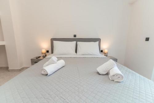 a large white bed with two towels on it at Hidden Paradise Apartment in Kos