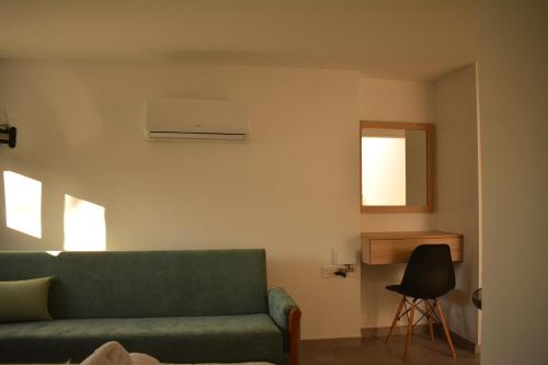 a living room with a green couch and a chair at Green Bay Suites in Protaras