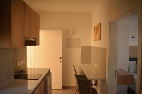a kitchen with a counter and a table in a room at Green Bay Suites in Protaras