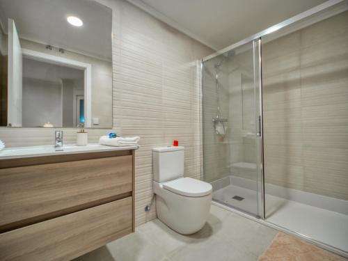 a bathroom with a toilet and a shower and a sink at Amara Prime San Sebastian in San Sebastián