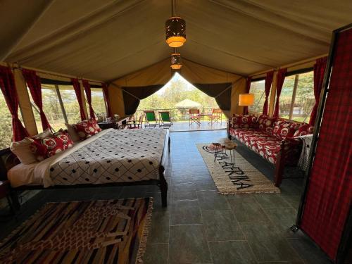a tent with a bed and chairs in a room at Nyumba ya Farasi in Naivasha