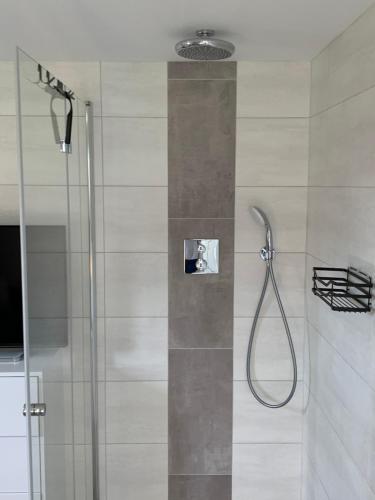 baño con ducha y puerta de cristal en Ferienzimmer Balou en Weener