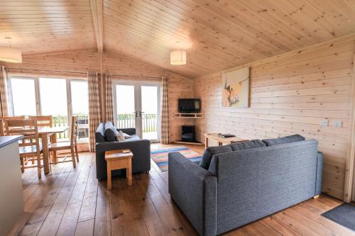 a living room with two couches and a table at Burgie Woodland Lodges in Forres
