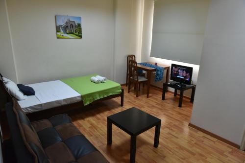 a room with a bed and a table and a tv at Elysium Capital Residence in Nicosia