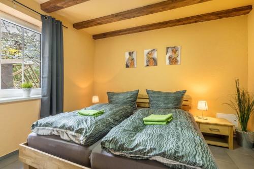 una camera da letto con un letto con piumone verde di Ferienwohnung Baumann a Schwarzenberg/Erzgebirge
