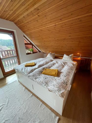 a bedroom with a large bed with a wooden ceiling at U farmy in Velhartice