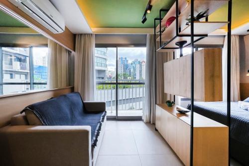 1 dormitorio con sofá, cama y ventana en Studio novíssimo, completo e muito bem localizado, en São Paulo
