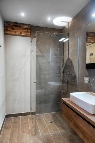 a bathroom with a glass shower and a sink at Residenz Illyrica Tirol in Westendorf