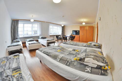 a bedroom with two beds and a living room at Twój Hostel Ruda Śląska in Ruda Śląska