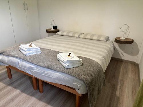 Casa Scaletta Santa Lucia في بيرغامو: منشفتان جالستان على سرير في غرفة