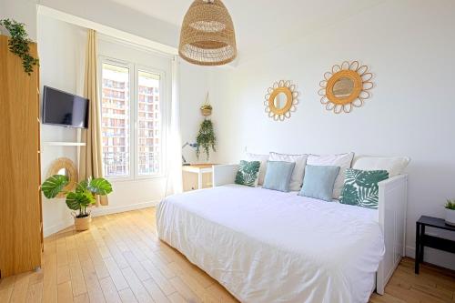 une chambre avec un lit blanc avec des oreillers bleus dans l'établissement Top floor studio near Montmartre, à Paris