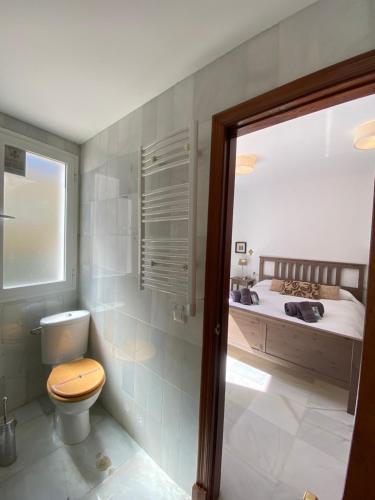 a bathroom with a toilet and a bed at MAGNÍFICO ÁTICO PLENO CENTRO. Terraza 60m. Climatizado, Garaje in Sanlúcar de Barrameda