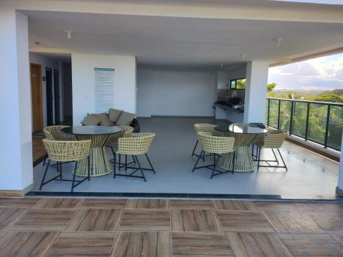 sala de estar con sillas, mesas y sofá en Maraca Beach I - Flat 102, en Porto de Galinhas