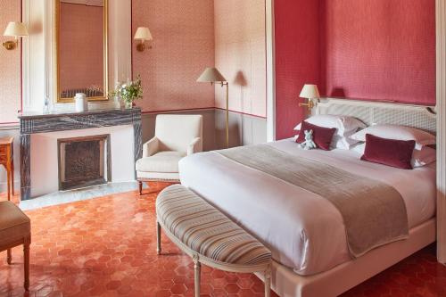 a bedroom with a large bed and a fireplace at Château de Fonscolombe in Le Puy-Sainte-Réparade