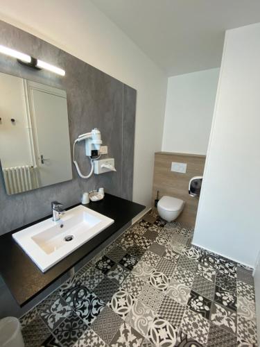 a bathroom with a sink and a toilet at Hotel du Louvre in Cherbourg en Cotentin
