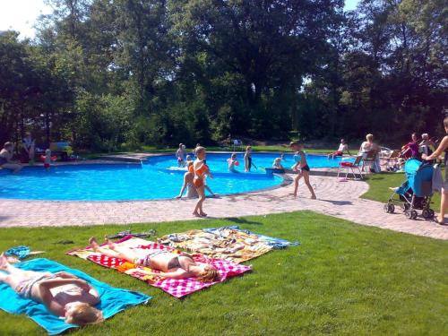 um grupo de pessoas deitadas em toalhas numa piscina em Familiepark de Vechtvallei em Diffelen