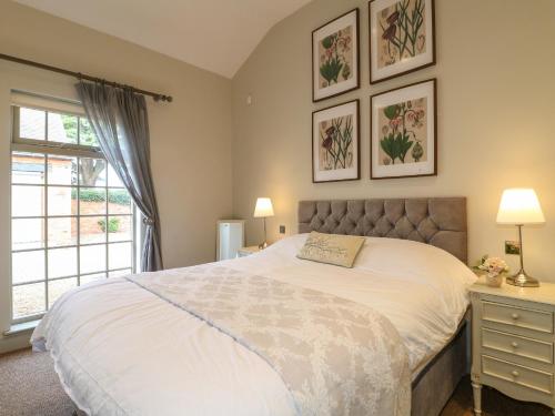 a bedroom with a large white bed with a window at The Cottage in Yoxall