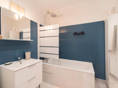 ein Badezimmer mit einem weißen Waschbecken und einer blauen Wand in der Unterkunft Le cocon d'Emile - Cosy et tout équipé in Nancy