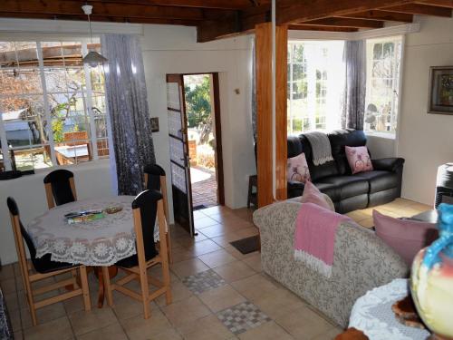 uma sala de estar com um sofá e uma mesa em Gentle Presence Cottages em Clarens