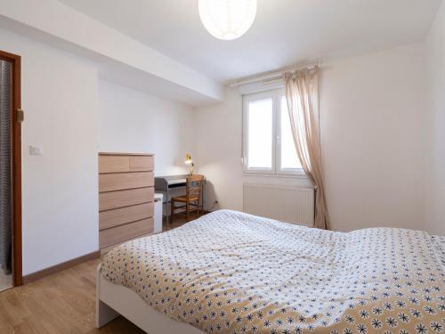 une chambre avec un lit, un bureau et une fenêtre dans l'établissement Le cocon d'Emile - Cosy et tout équipé, à Nancy