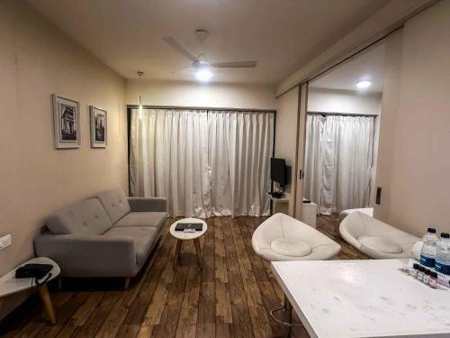 a living room with a couch and a table at Ambition studio apartment at rajhans belliza in Dumas