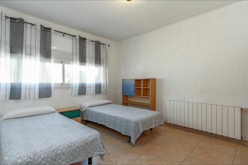 een slaapkamer met twee bedden en een raam bij Villa Atenea in Lloret de Mar