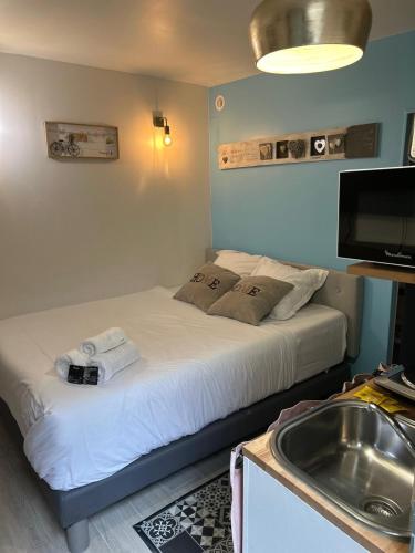 - une petite chambre avec un lit, un lavabo et une télévision dans l'établissement Joli studio rue de Nazareth, à Paris