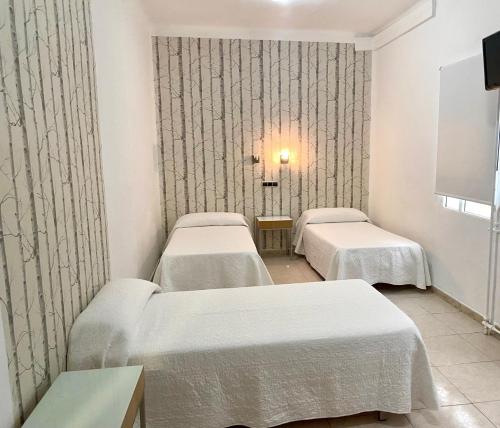 a hospital room with two beds and a tv at Hotel Alamo in Alicante