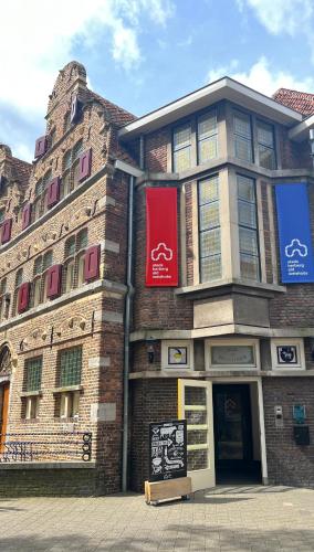 a brick building with signs on the side of it at Stadsherberg Ald Weishoès - Hostel in Venlo