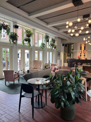a lobby with tables and chairs and a waiting room at Stadsherberg Ald Weishoès - Hostel in Venlo