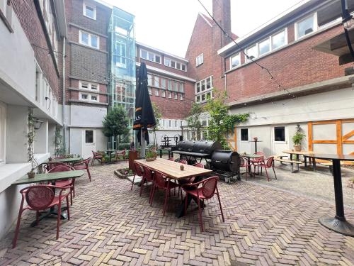 a patio with tables and chairs in a courtyard at Stadsherberg Ald Weishoès - Hostel in Venlo