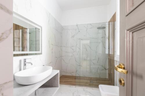 La salle de bains blanche est pourvue d'un lavabo et d'une douche. dans l'établissement Louly Spanish Steps, à Rome