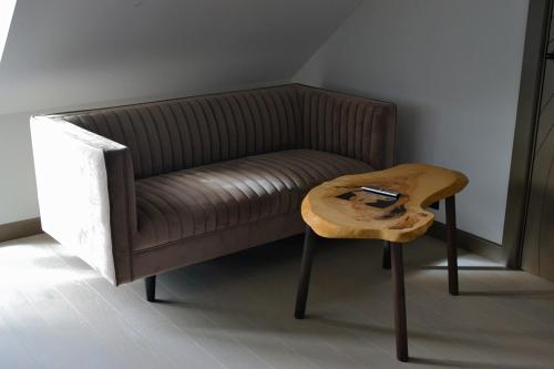 a brown couch with a wooden table next to a stool at Andenes Suitehotel in Andenes