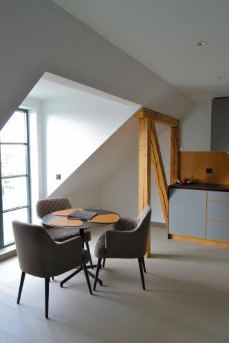 a table and chairs in a room with a staircase at Andenes Suitehotel in Andenes