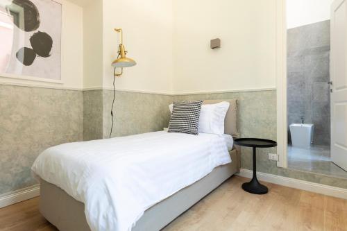 a bedroom with a bed with a lamp and a table at Louly Spanish Steps in Rome