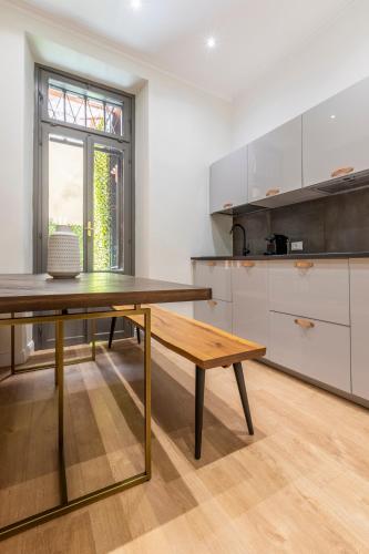 a kitchen with a wooden table and a bench at Louly Spanish Steps in Rome