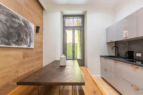 a kitchen with a wooden table and a window at Louly Spanish Steps in Rome