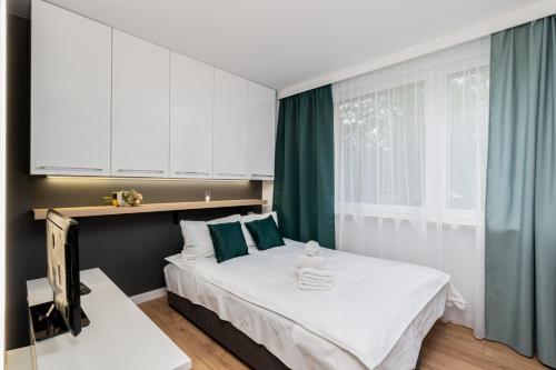 sypialnia z dużym łóżkiem z zielonymi zasłonami w obiekcie Prokocim Modern Studio w Krakowie