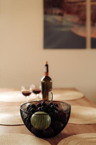 a bowl of grapes on a table with a bottle of wine at Morze Tu in Stegna